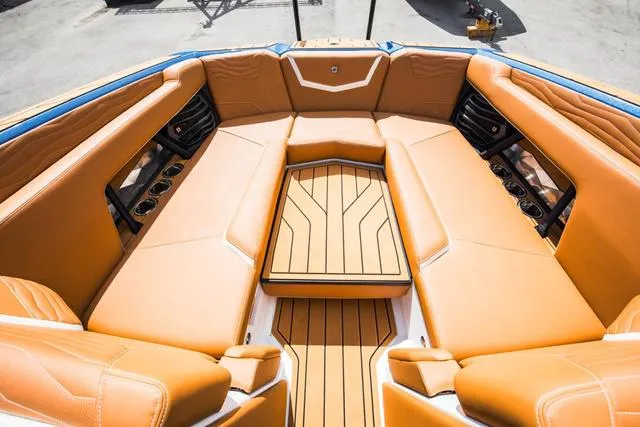 Slide: The Image of Luxurious 2025 Nautique G25 boat interior with tan leather seating and wood accents. - 11