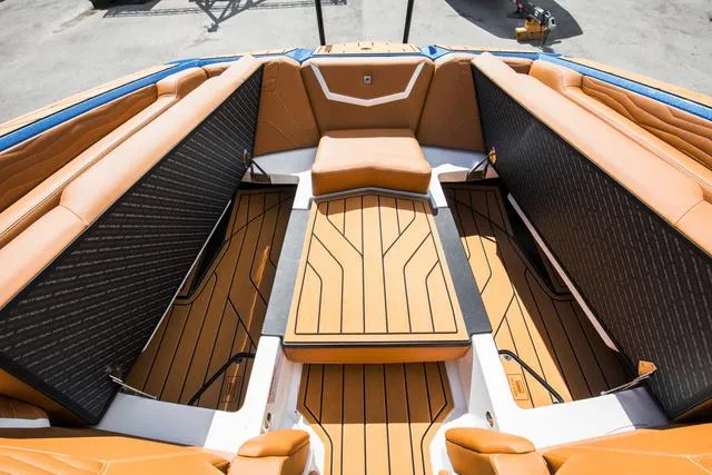 Slide: The Image of 2025 Nautique G25 boat interior with tan and black seating, sleek design. - 13