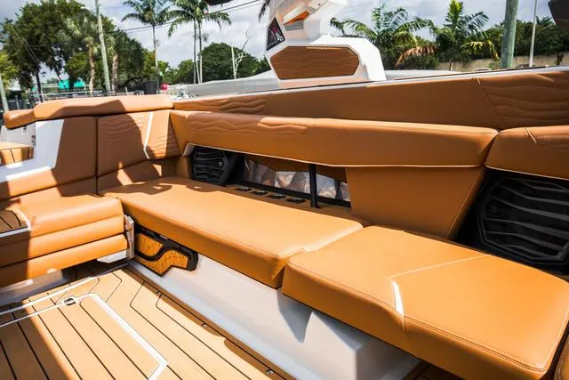 Slide: The Image of 2025 Nautique G25 boat interior with tan leather seating and sleek design. - 16