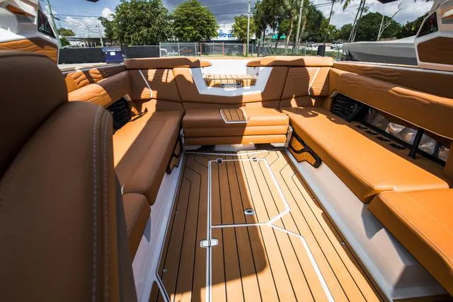 Slide: The Image of 2025 Nautique G25 boat interior with luxurious tan seating and teak flooring. - 17