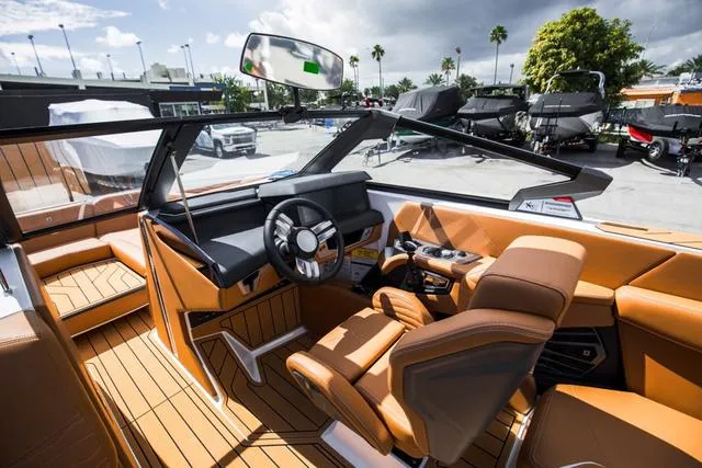 Slide: The Image of Interior of 2025 Nautique G25 boat with luxurious tan seating and modern dashboard. - 20