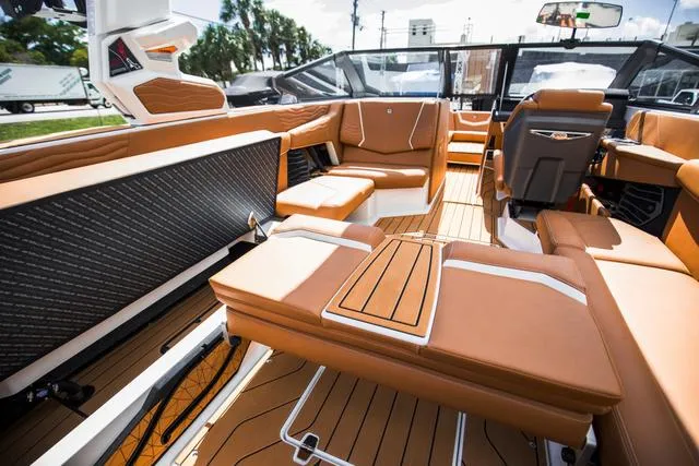 Slide: The Image of Luxurious interior of 2025 Nautique G25 boat with tan leather seating and wood accents. - 23