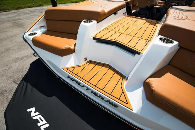 Slide: The Image of 2025 Nautique G25 boat with tan seating and teak-style decking. - 24