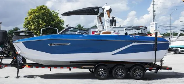 Slide: The Image of 2025 Nautique G25 boat on trailer, blue and white design, parked outdoors. - 3