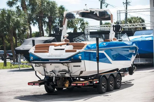 Slide: The Image of 2025 Nautique G25 boat on trailer, blue and white design, parked outdoors. - 5