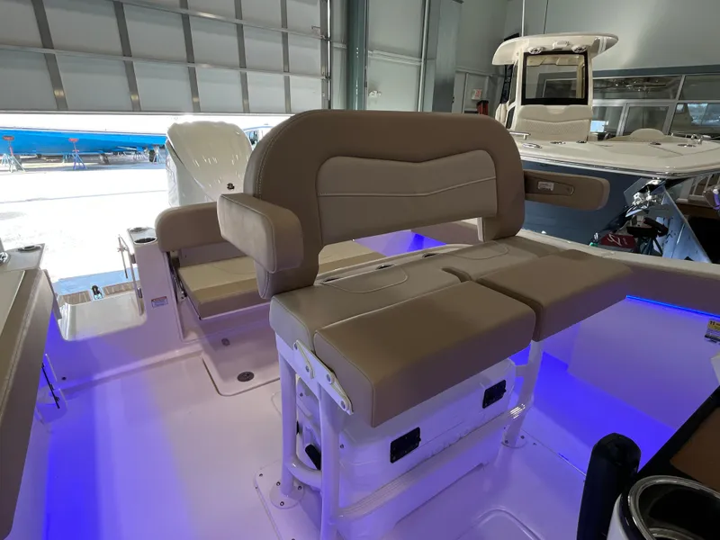 Slide: The Image of 2025 Scout 240 XSF boat interior with beige seating and blue LED lighting. - 13