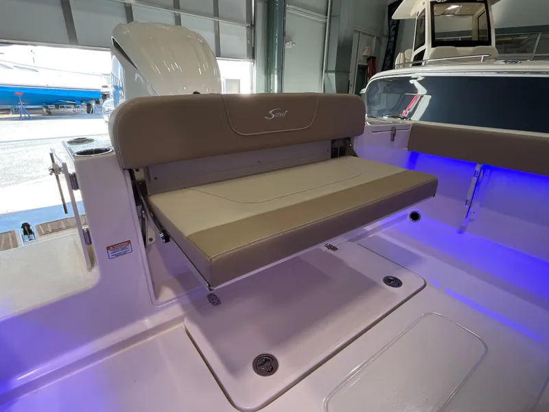 Slide: The Image of 2025 Scout 240 XSF boat interior with foldable seat and ambient blue lighting. - 14