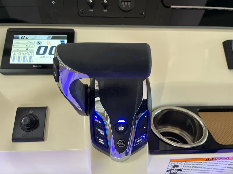 Slide: The Image of 2025 Scout 240 XSF boat throttle control with digital display and cup holder. - 18