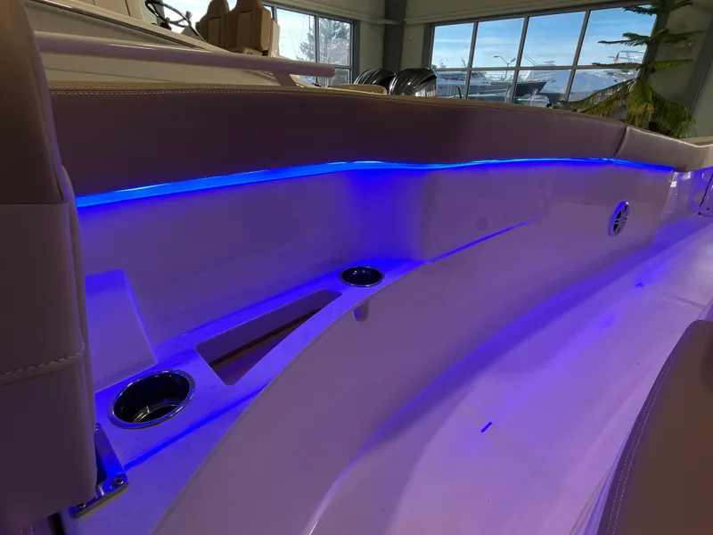 Slide: The Image of 2025 Scout 240 XSF boat interior with blue LED lighting and cup holders. - 20