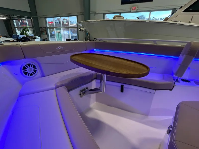 Slide: The Image of 2025 Scout 240 XSF boat interior with blue LED lighting and wooden table. - 22