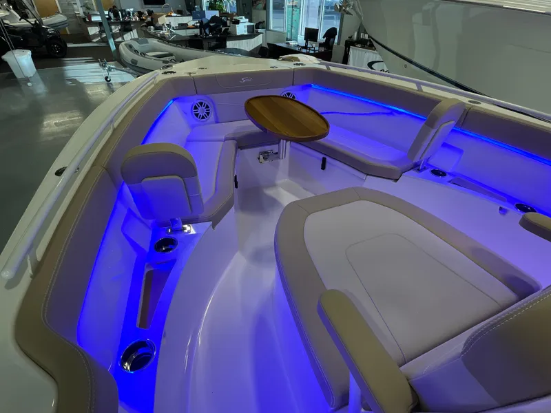 Slide: The Image of 2025 Scout 240 XSF boat interior with blue LED lighting and seating area. - 23