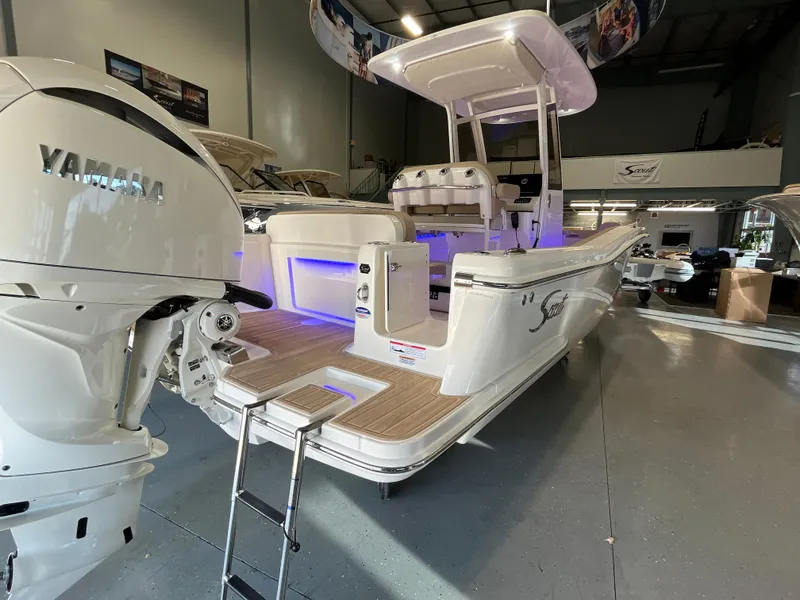 Slide: The Image of 2025 Scout 240 XSF boat with Yamaha engine in showroom, featuring modern design and lighting. - 5