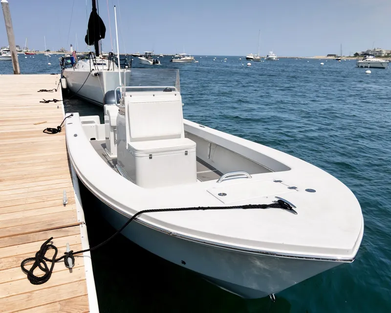 Slide: The Image of 2023 Jones Brothers 23 Cape Fisherman boat docked on calm blue water. - 4