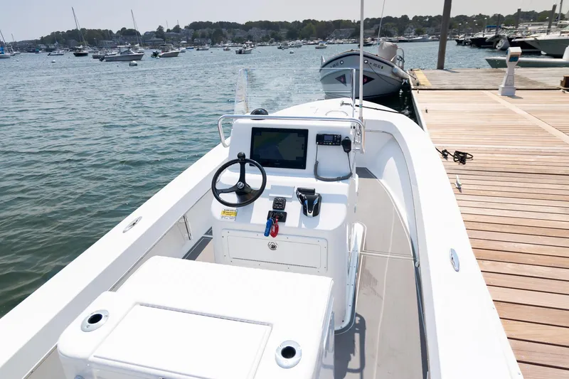Slide: The Image of 2023 Jones Brothers 23 Cape Fisherman boat docked at marina, featuring modern helm controls. - 9