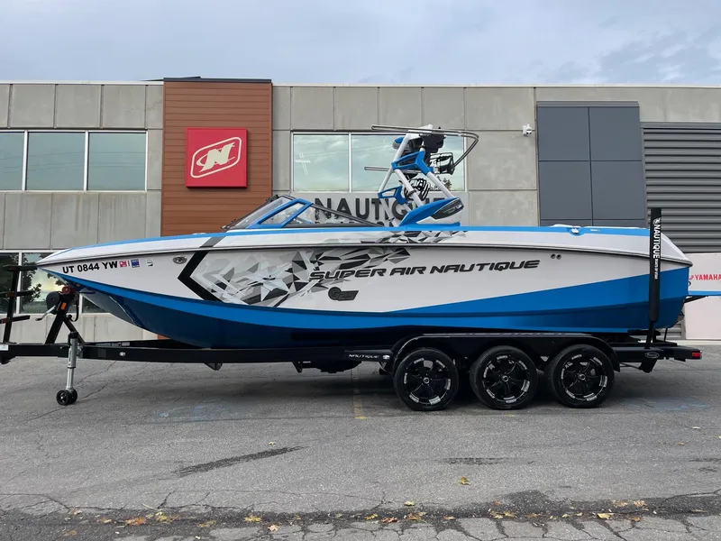Slide: The Image of 2015 Nautique Super Air Nautique G25 boat on trailer, parked outside dealership. - 1