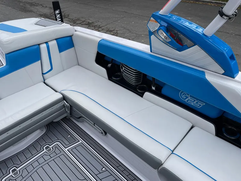 Slide: The Image of 2015 Nautique Super Air Nautique G25 interior with blue and white seating. - 9