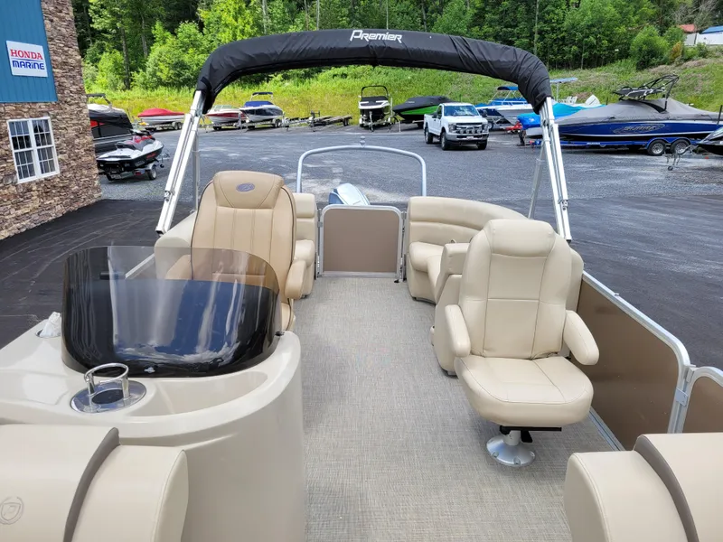 Slide: The Image of 2022 Premier 220 Sunspree RF pontoon boat with beige seating and canopy in a marina. - 8