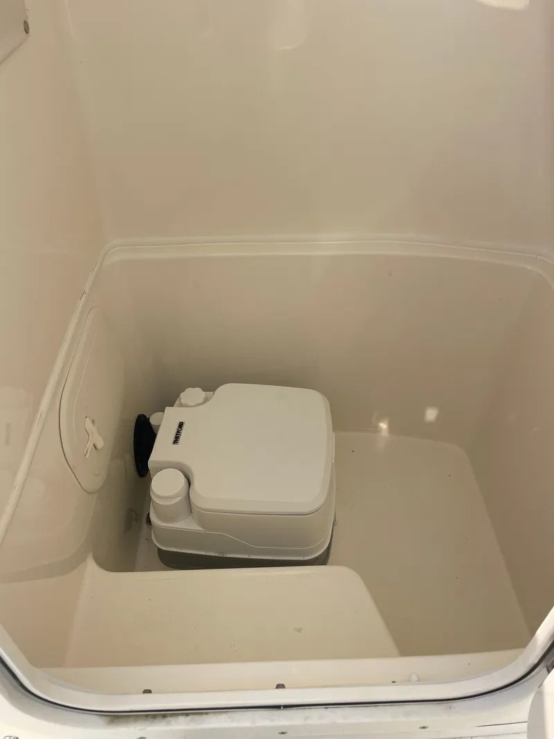Slide: The Image of Portable toilet inside 2022 Cobia 220 Center Console boat compartment. - 11