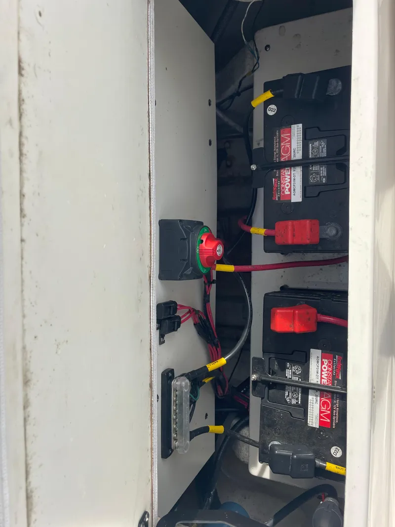 Slide: The Image of 2022 Cobia 220 Center Console boat battery compartment with wiring and connections. - 15