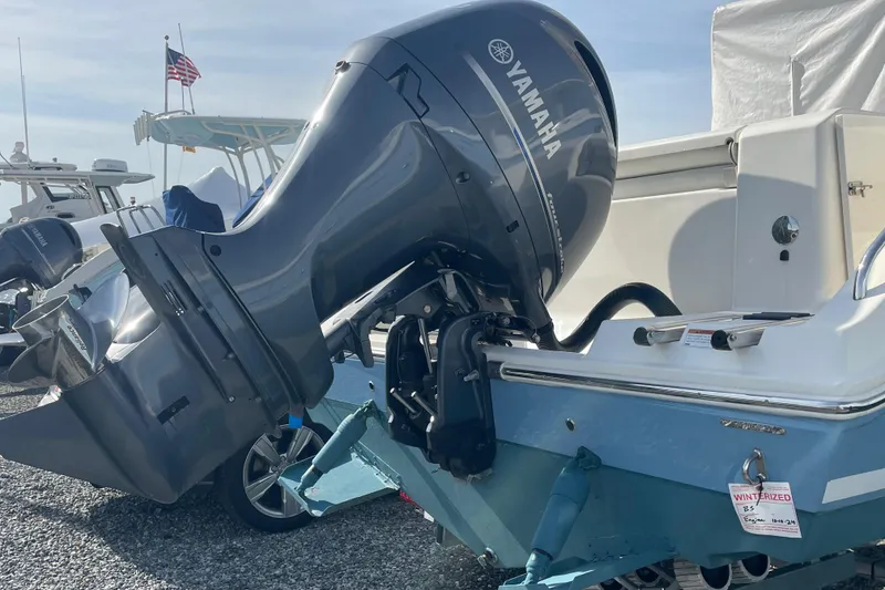Slide: The Image of 2022 Cobia 220 Center Console with Yamaha outboard motor, parked on gravel. - 3