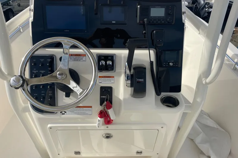 Slide: The Image of 2022 Cobia 220 Center Console boat dashboard with steering wheel and controls. - 4