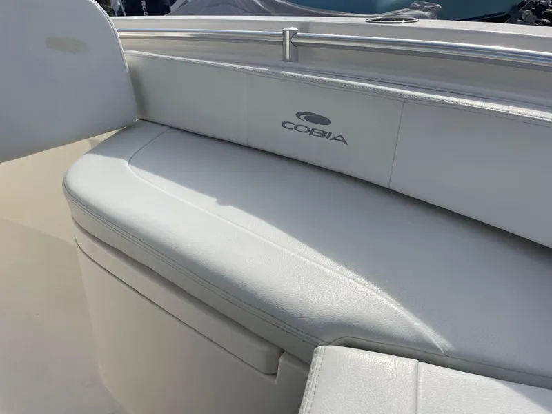 Slide: The Image of 2022 Cobia 220 Center Console boat with white cushioned seating. - 8