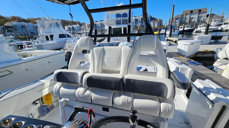 Slide: The Image of 2021 Blackfin 332 CC boat interior at marina, featuring plush seating and modern design. - 29