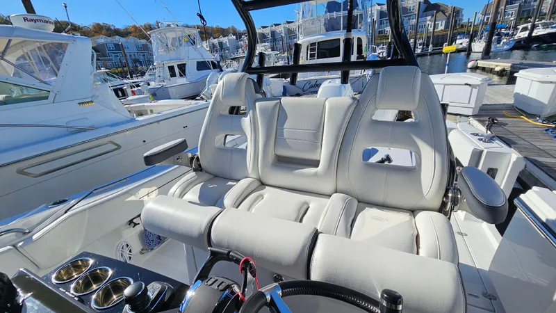 Slide: The Image of 2021 Blackfin 332 CC boat interior with luxurious seating at a marina. - 31