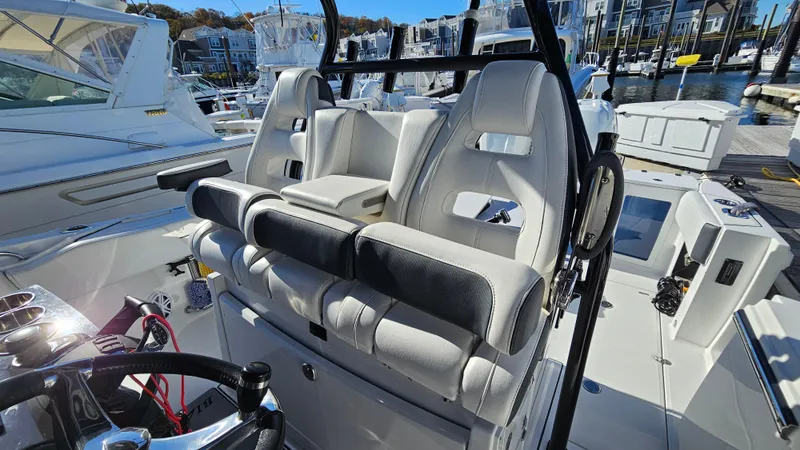 Slide: The Image of 2021 Blackfin 332 CC boat interior with plush seating at a marina. - 32