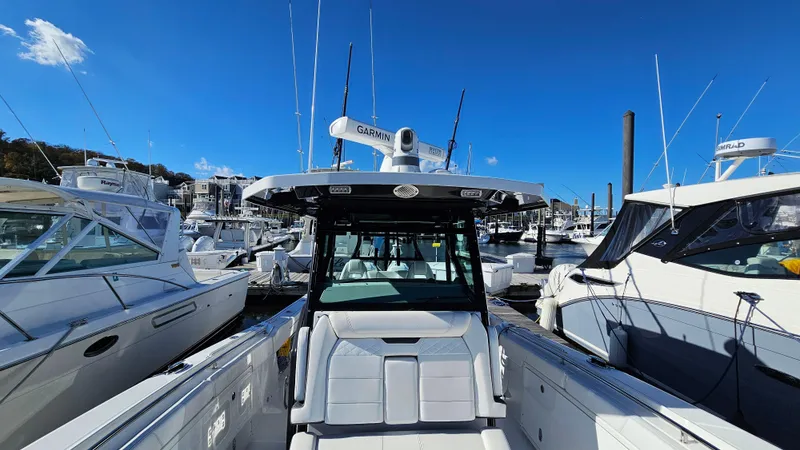 Slide: The Image of 2021 Blackfin 332 CC boat docked among other vessels under a clear blue sky. - 44
