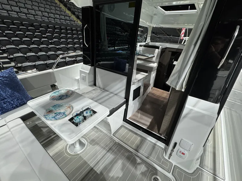 The Image of 2025 Jeanneau NC 895 Sport Series 2 boat displayed indoors with flags. - 1