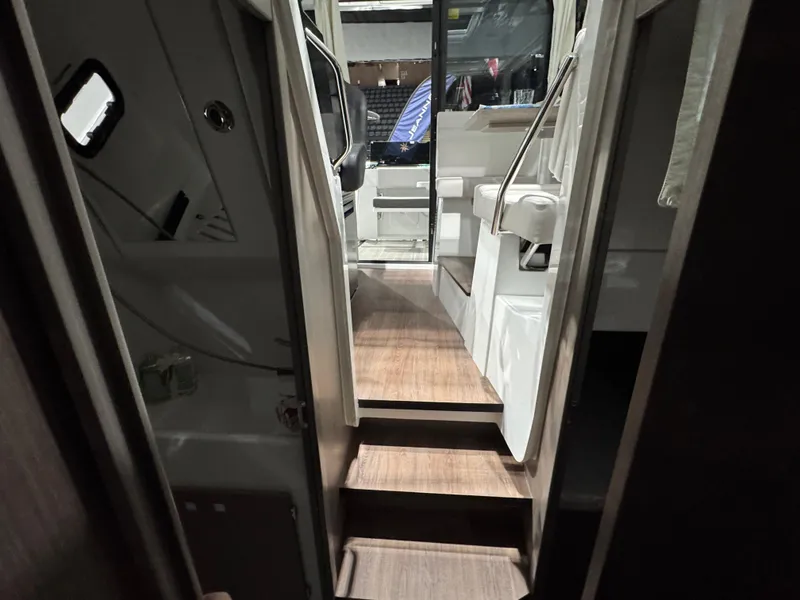 Slide: The Image of Interior view of 2025 Jeanneau NC 895 Sport Series 2, featuring wooden steps and modern design. - 22