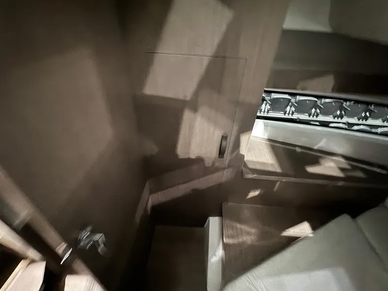 Slide: The Image of Interior view of 2025 Jeanneau NC 895 Sport Series 2, featuring wooden stairs and modern design. - 21