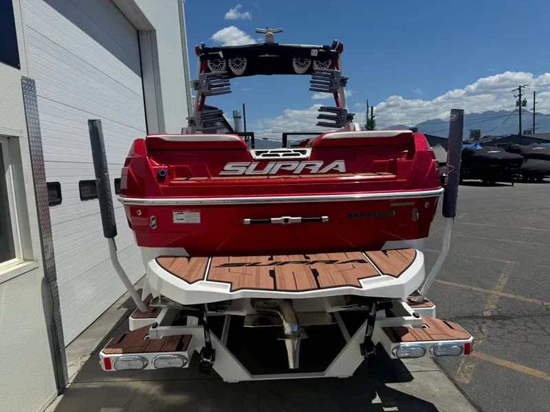 Slide: The Image of 2023 Supra SL 550 boat, red exterior, parked outdoors, rear view. - 4