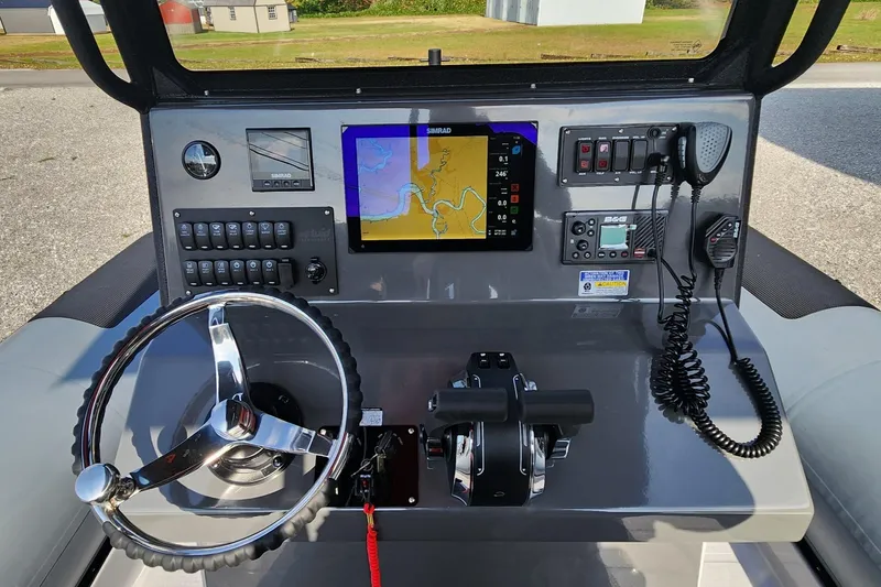 Slide: The Image of Control panel of 2025 Fluid Watercraft Patrol 26 with navigation screen and steering wheel. - 10