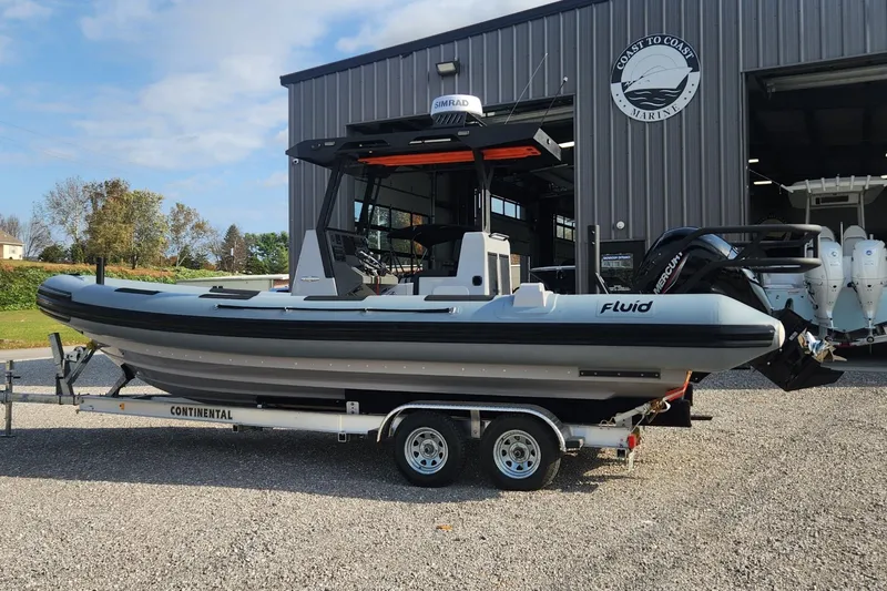 Slide: The Image of 2025 Fluid Watercraft Patrol 26 boat on trailer outside a marine facility. - 17