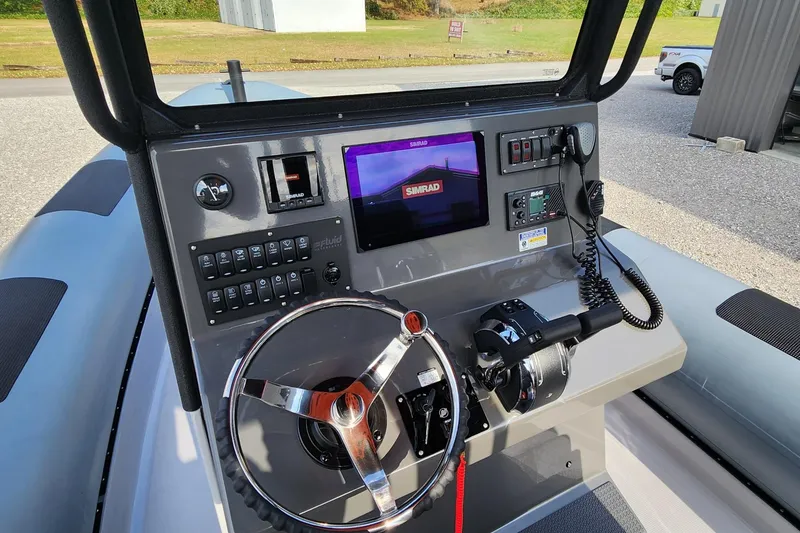 Slide: The Image of Control panel of 2025 Fluid Watercraft Patrol 26 boat with steering wheel and navigation screen. - 18