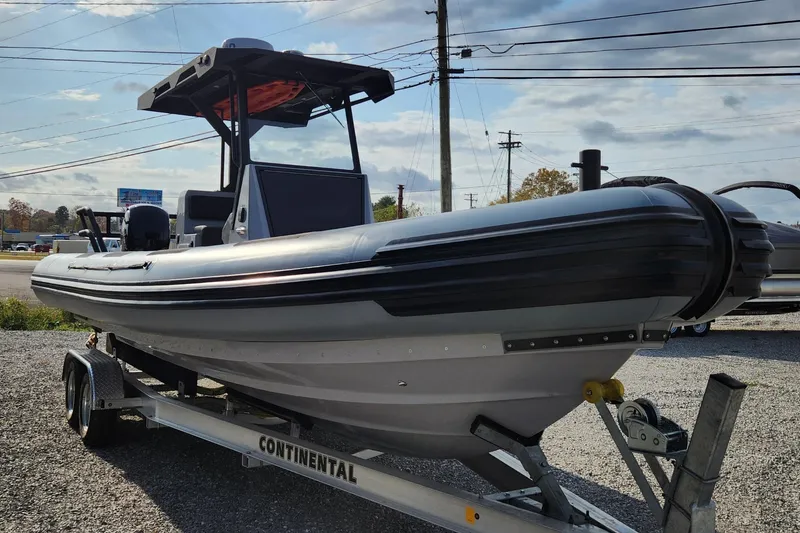 Slide: The Image of 2025 Fluid Watercraft Patrol 26 boat on trailer, side view, outdoors. - 2