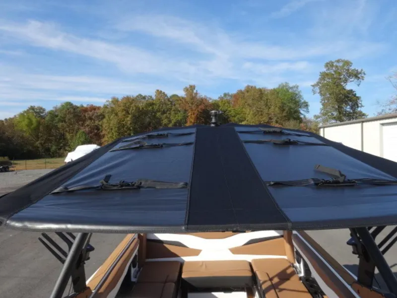 Slide: The Image of 2025 Axis T235 boat with black canopy, parked outdoors under a blue sky. - 20