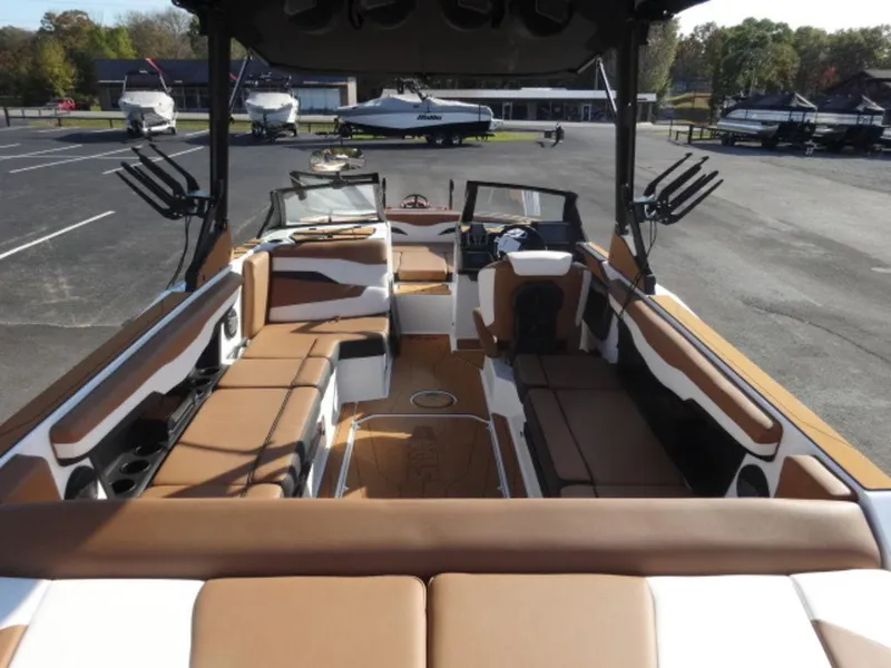 Slide: The Image of 2025 Axis T235 boat interior with brown and white seating, parked in a marina. - 3