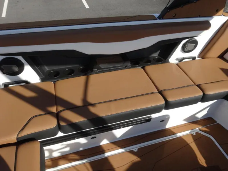 Slide: The Image of 2025 Axis T235 boat interior with brown cushioned seating and integrated speakers. - 5