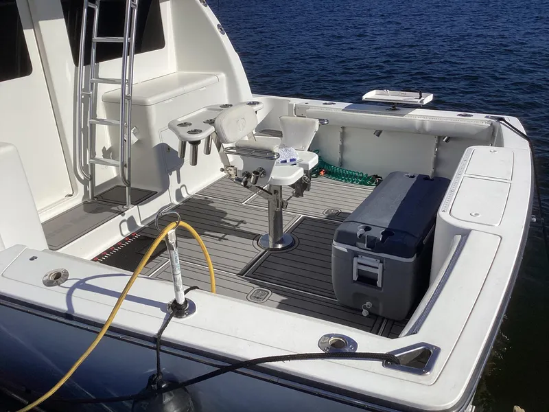 Slide: The Image of Henriques 35 Flybridge 2006 boat deck with fishing chair and cooler on calm water. - 14