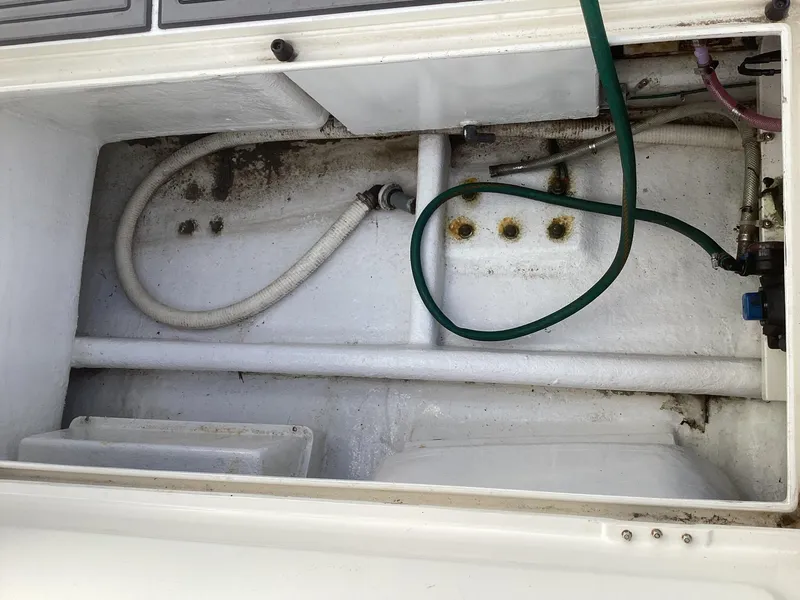 Slide: The Image of 2006 Henriques 35 Flybridge boat storage compartment with hoses and fittings. - 19