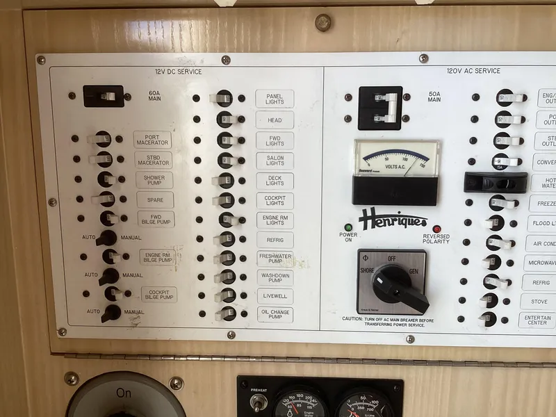 Slide: The Image of Control panel of a 2006 Henriques 35 Flybridge boat, showing switches and gauges. - 26
