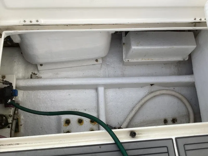 Slide: The Image of Open engine compartment of 2006 Henriques 35 Flybridge boat, showing hoses and storage space. - 27