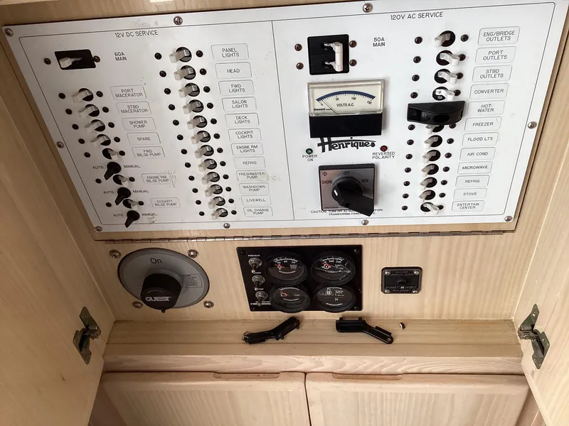 Slide: The Image of Electrical panel of a 2006 Henriques 35 Flybridge boat, featuring various switches and gauges. - 35