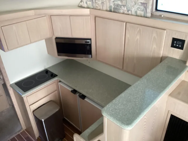 Slide: The Image of Henriques 35 Flybridge 2006 boat kitchen with modern appliances and wooden cabinetry. - 38