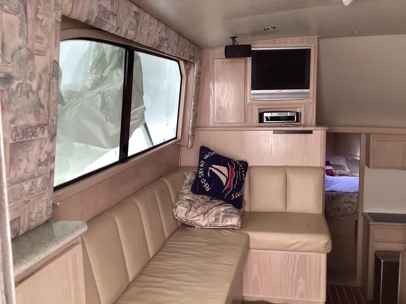 Slide: The Image of Interior of 2006 Henriques 35 Flybridge with beige seating, TV, and nautical decor. - 42