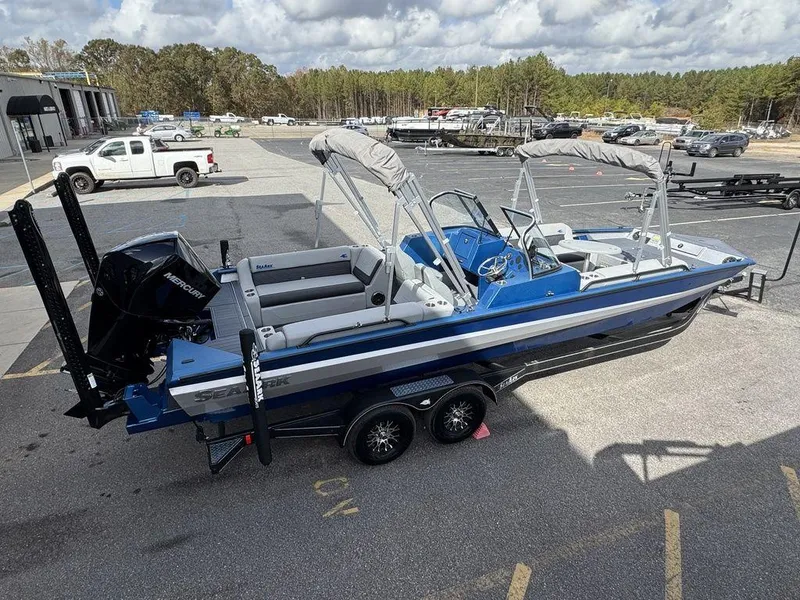 Slide: The Image of 2025 SeaArk Super Lounge Easy boat in parking lot, blue and white design, dual engines. - 11