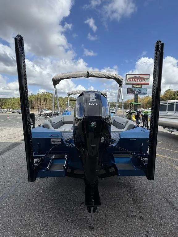 Slide: The Image of 2025 SeaArk Super Lounge Easy boat with powerful outboard motor, parked outdoors. - 5